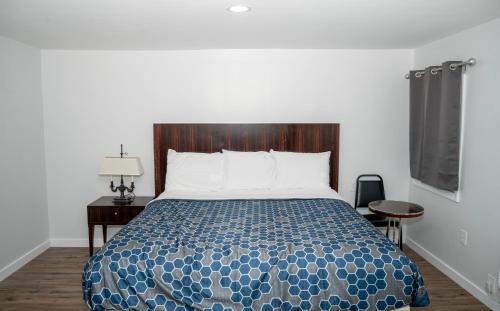 a bedroom with a large bed with a wooden headboard at Rainbow Motel in Douglassville