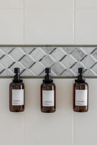 three bottles of soap on a shelf in a bathroom at New Reno Retreat 72 Inch TV Office Patio Views in Reno