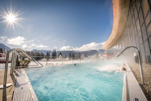 a swimming pool with water spraying out of a building at MiHome - Grimming View Apartment in Tauplitz
