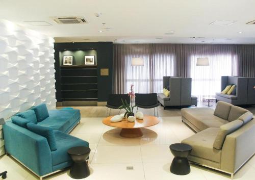 a living room with couches and a table at Helbor Stay Gonzaga - Suíte moderna a 5 min da praia in Santos