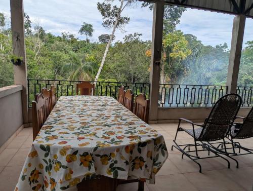 a table and chairs on a balcony with a view of the forest at Refúgio na Floresta in Manaus