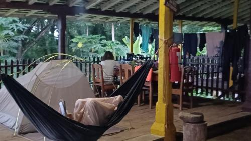 a hammock in a restaurant with a person in the background at Eco lodge finca magdalena in Altagracia