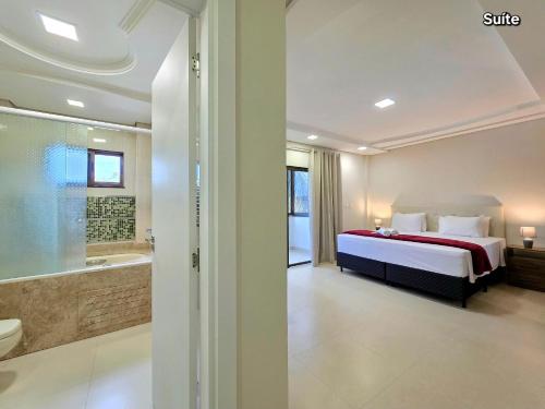 pokój hotelowy z łóżkiem i wanną w obiekcie Apt 02 Alto Padrão 3 quartos ao lado do Paraguai w Foz do Iguaçu