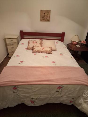 a bedroom with a large bed with flowers on it at Apto Fofo com Natureza em Serra Negra in Serra Negra