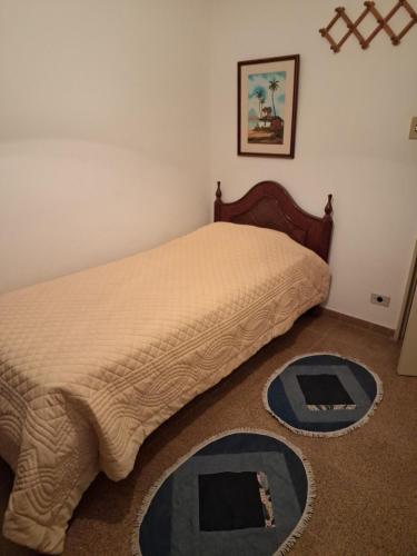 a bedroom with a bed with a comforter on the floor at Apto Fofo com Natureza em Serra Negra in Serra Negra