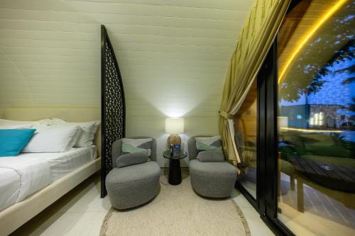 a bedroom with a bed and two chairs and a table at Shades Beach Club in Jeddah
