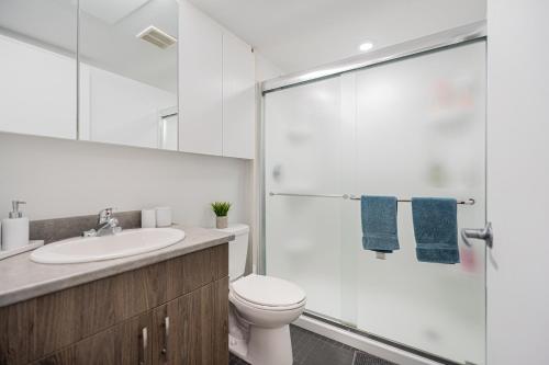 a bathroom with a toilet and a glass shower at Top Location - Cozy & Bright MTL studio near metro in Montréal