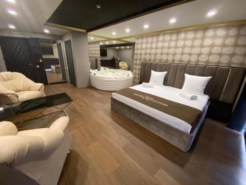 a bedroom with a bed and a bath room with a tub at Viagio in Yerevan