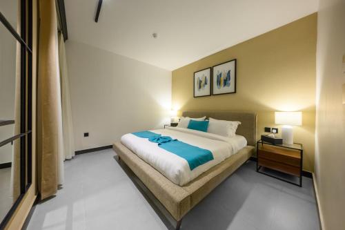 a bedroom with a large bed and a night stand at Shades Beach Club in Jeddah