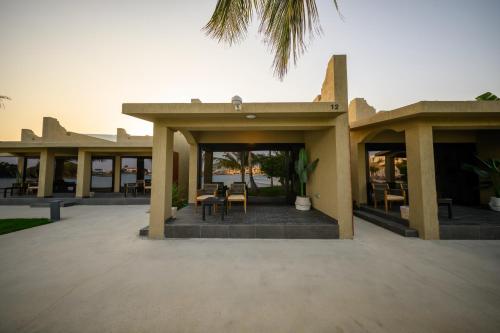 a building with a patio with tables and chairs at Shades Beach Club in Jeddah