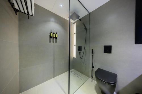 a bathroom with a glass shower and a toilet at Shades Beach Club in Jeddah