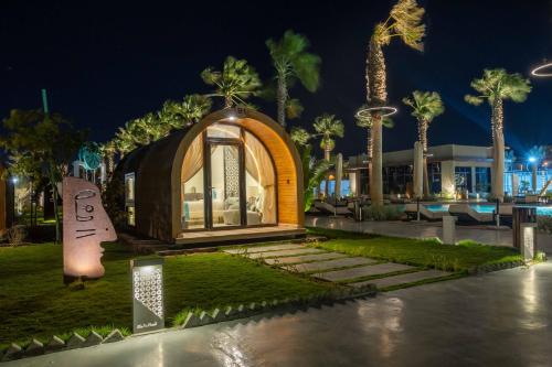 a gazebo in a park with palm trees at night at Shades Beach Club in Jeddah