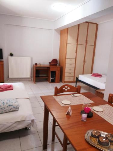 a room with two beds and a table and chairs at Apostolos House in Panagioúda