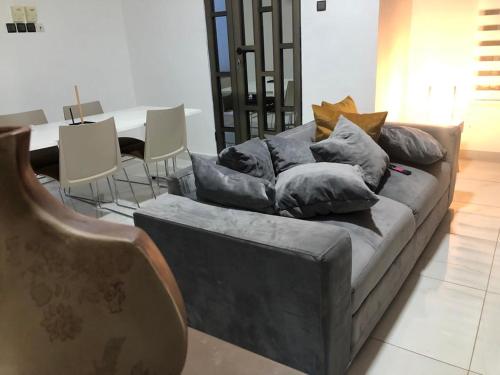 コトヌーにあるAppartement Performance luxury HOUEYIHOのリビングルームにある枕が置かれたソファ