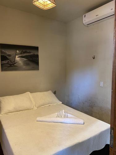 a bed with a towel on it in a room at Casa de praia do pescador in Trairi