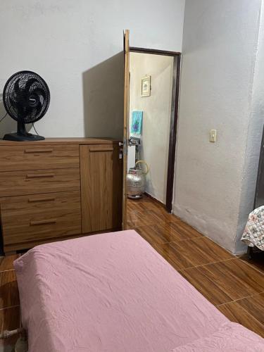a bedroom with a bed and a room with a fan at Casa de praia do pescador in Trairi