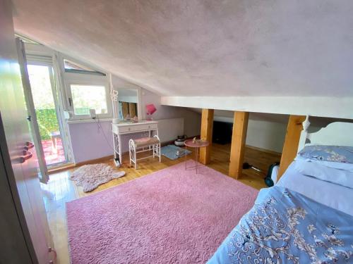 a bedroom with a large bed and a pink rug at miris dunja in Sarajevo