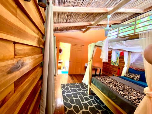 a bedroom with a bunk bed and a wooden wall at La Shamana - Ecological Concept in Jungle in Cahuita
