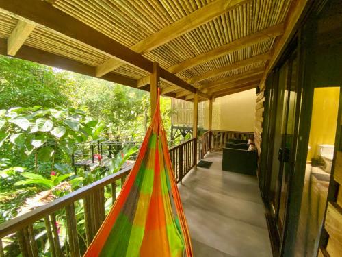 a porch with a hammock on a balcony at La Shamana - Ecological Concept in Jungle in Cahuita