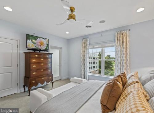 米尔斯伯勒Fabulous on the Fairway!的一间卧室配有一张床和一个带电视的梳妆台