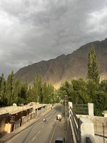 a road with motorcycles on it with mountains in the background at Aba-SHAH GUEST HOUSE SKARDU in Skardu