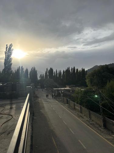 a view of a road with the sun in the distance at Aba-SHAH GUEST HOUSE SKARDU in Skardu