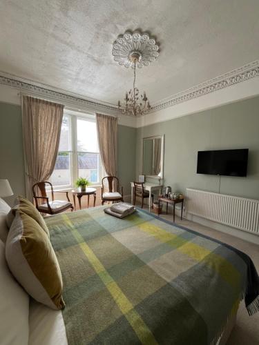 a bedroom with a bed and a flat screen tv at Acorn House Callander in Callander