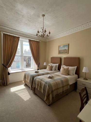 a bedroom with a large bed and a window at Acorn House Callander in Callander