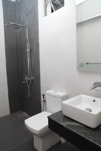 a bathroom with a sink and a toilet and a shower at ARON'S Lavinia RUBY in Mount Lavinia