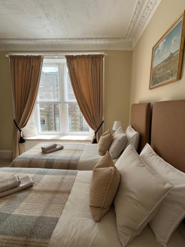 a bedroom with two beds and a window at Acorn House Callander in Callander