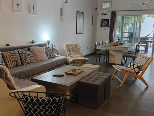 a living room with a couch and a table at Villa JAJA Piscine-Climatisation in Poponguine