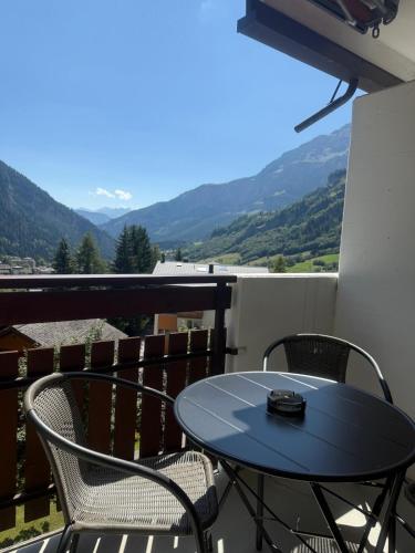 a table and chairs on a balcony with mountains at Goliath 44 & 45 in Leukerbad