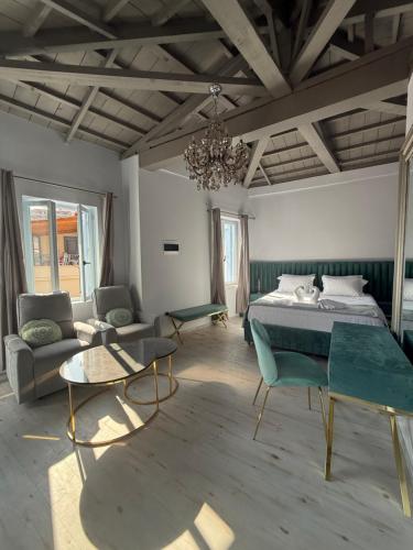 a bedroom with a bed and a couch and a table at Gorgeous restored house at Platanos square in Lésvos