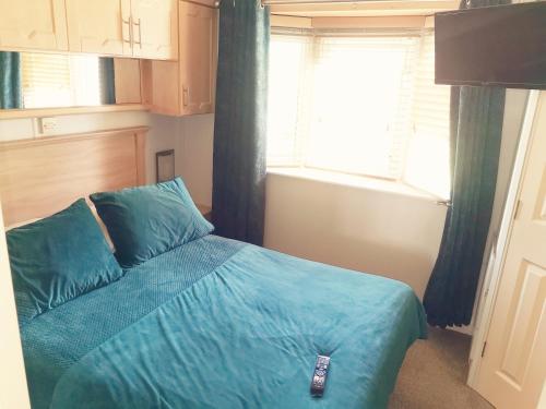 a bedroom with a blue bed with a remote control on it at Beautiful scenery in Startforth