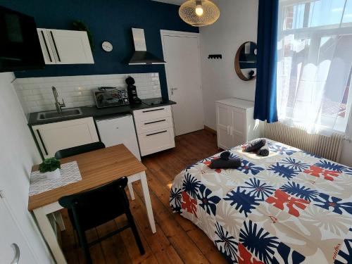 a kitchen with a bed and a table in a room at N3 - Charmant Studio Central in Valenciennes