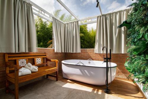 a bathroom with a tub in a room with windows at Casa Sabor Chocolate in Campos do Jordão