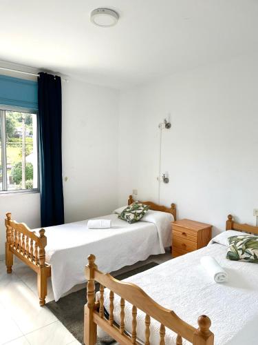 a bedroom with two beds and a window at A Senda in Caldas de Reis