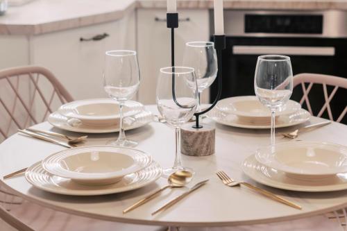 a table with plates and wine glasses on it at Lindos Zen luxury villa in Líndos