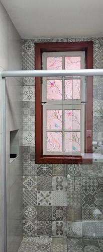 a bathroom with a window and a walk in shower at Solar dos Reis Apartamento Topázio in Ouro Preto