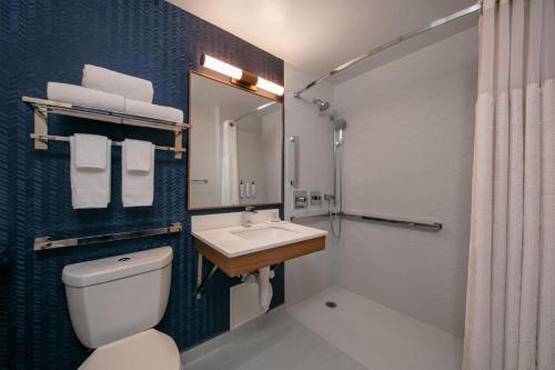a bathroom with a white toilet and a sink at Fairfield Inn by Marriott JFK Airport in Queens