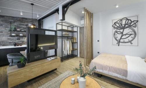een slaapkamer met een bed en een tv in een kamer bij Olvios Lofts @Ladadika in Thessaloniki