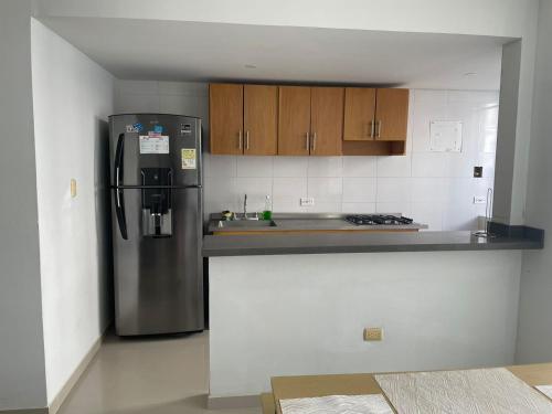 a kitchen with a stainless steel refrigerator and wooden cabinets at Vacaciones Inolvidables in Coveñas