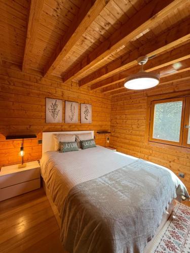 a bedroom with a large bed in a wooden room at Gerês Nature House Piscina Privada Aquecida 8 Pessoas in Campo do Gerês