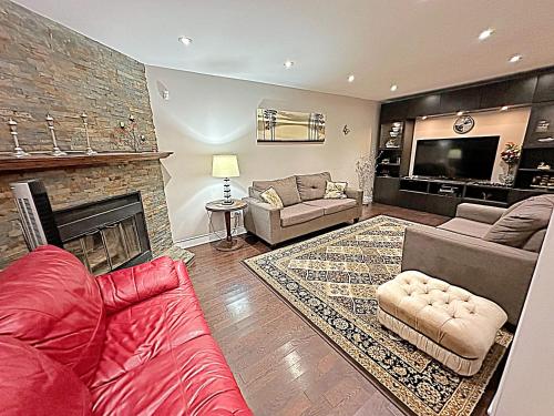 a living room with a red couch and a fireplace at Beautiful House in Mississauga in Mississauga