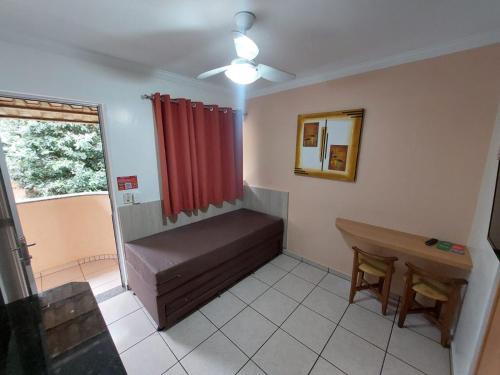 a room with a bench and a window with a red curtain at diRoma Fiori - Apartamentos JN in Caldas Novas