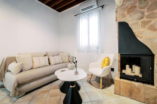 a living room with a couch and a fireplace at Lindos Zen luxury villa in Líndos