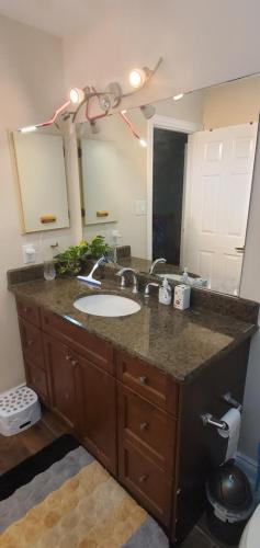 Un baño con lavabo y un espejo grande. en Beautiful House in Mississauga, en Mississauga