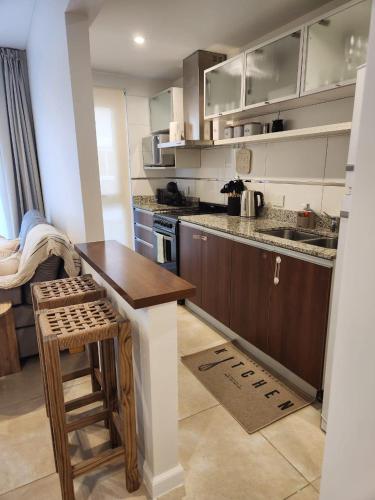 a kitchen with a counter and a table in it at Departamento Banfield Centro in Lomas de Zamora
