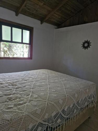 a bed in a bedroom with a clock on the wall at Lacaune Haus in São Francisco de Paula