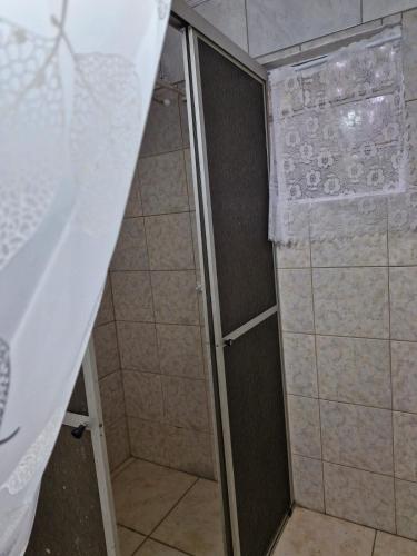 a shower with a shower curtain in a bathroom at Lacaune Haus in São Francisco de Paula